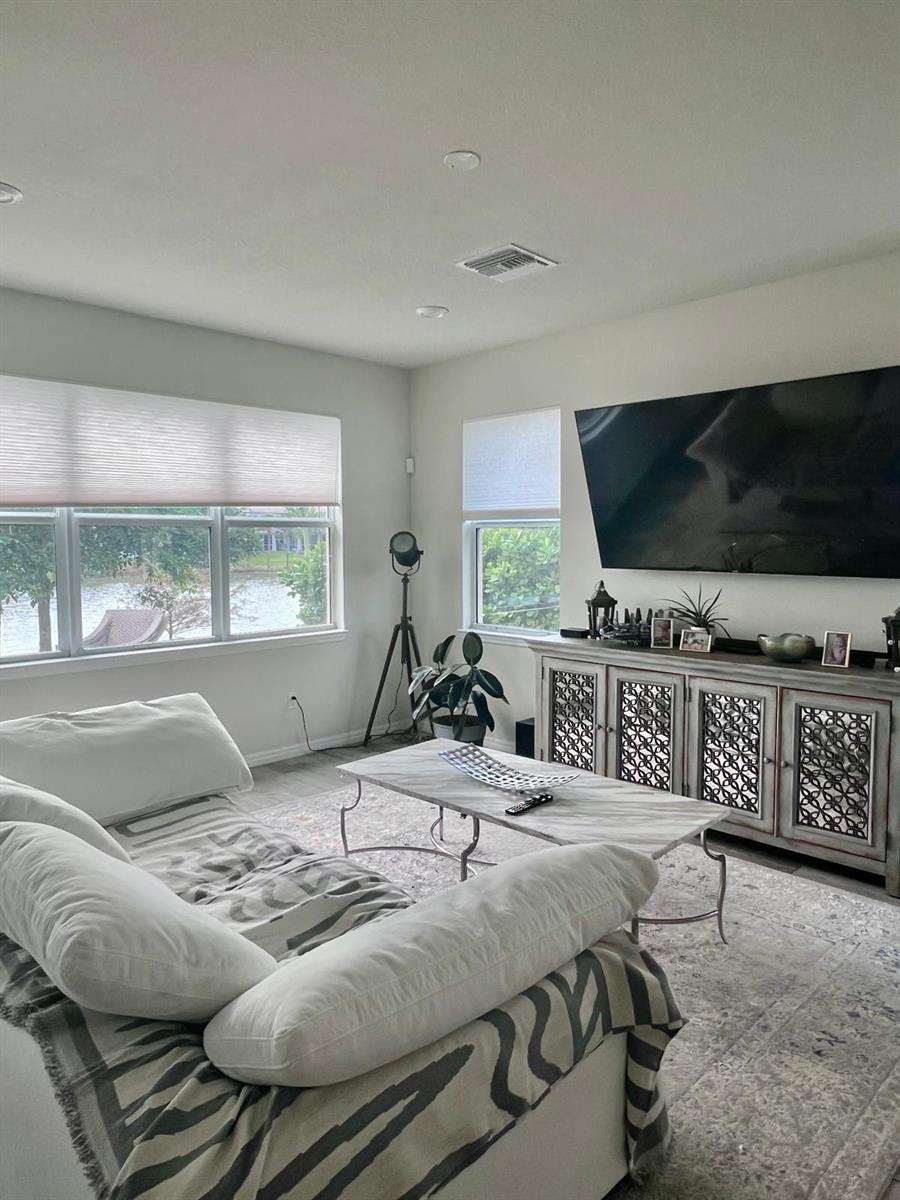 A living room features a white sofa, marble coffee table, media console, and large windows — 4924 Greenway Drive, Hollywood FL 33021, HOLLYWOOD, FL
