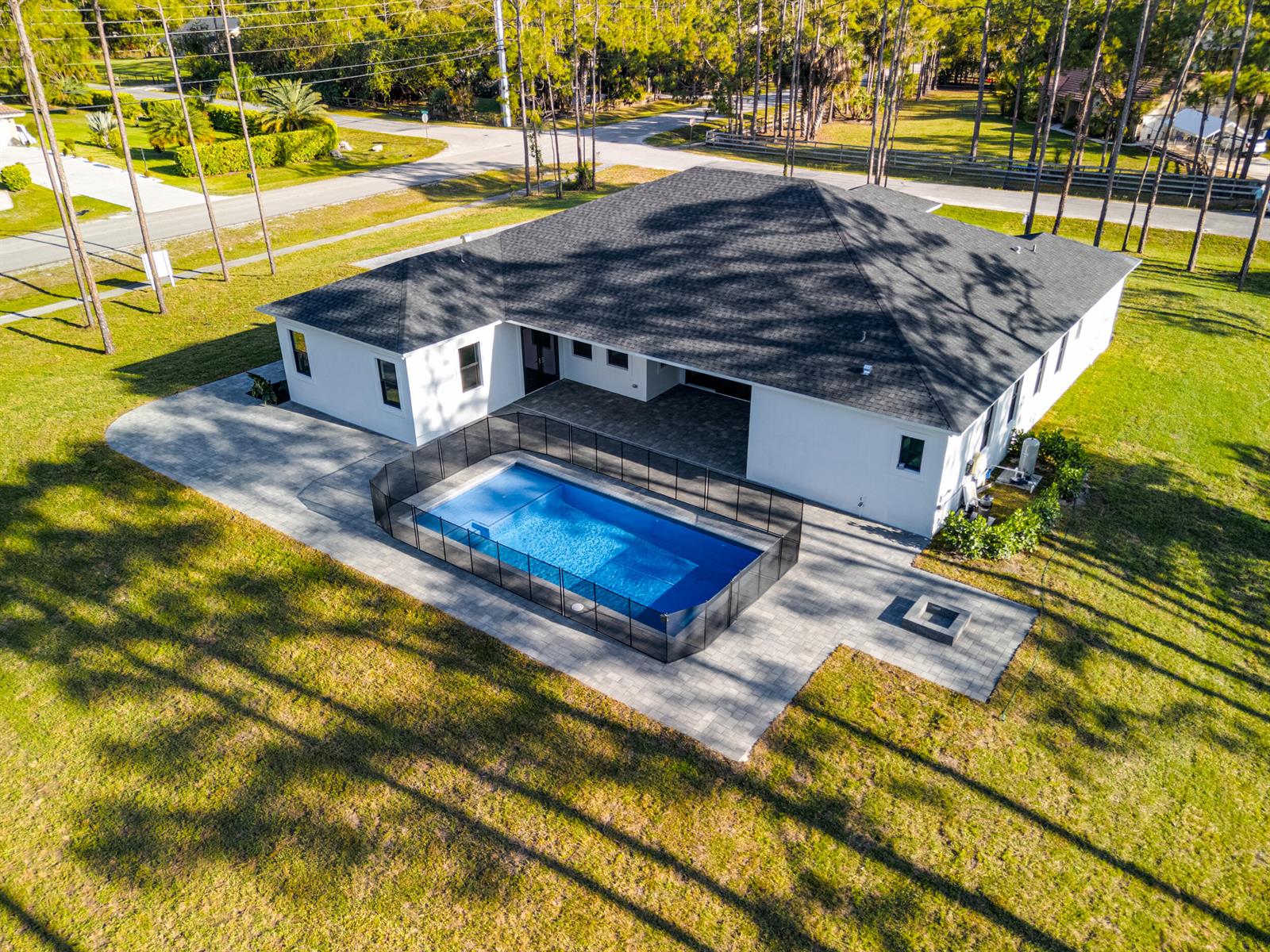 An aerial view of a white house with a black roof and a fenced pool — 17975 81st Lane N, Loxahatchee FL 33470, LOXAHATCHEE, FL