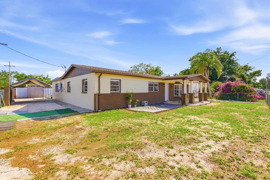 A single-story house with a brown brick base, light-colored siding, and a detached carport — 3002 W HAYA STREET, TAMPA, FL