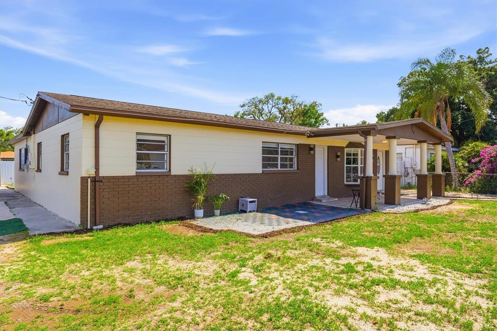 A single-story house with a brown brick lower exterior and cream-colored upper siding — 3002 W HAYA STREET, TAMPA, FL