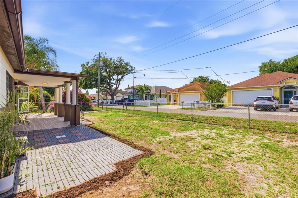 A backyard with a paved patio, a covered porch, and a chain-link fence — 3002 W HAYA STREET, TAMPA, FL