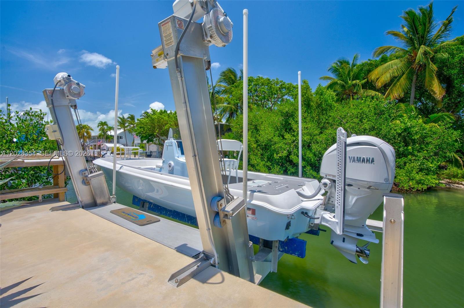 A white motorboat with a Yamaha outboard engine sits on a metal boat lift — 145 Venetian Drive, Islamorada FL 33036, ISLAMORADA, FL