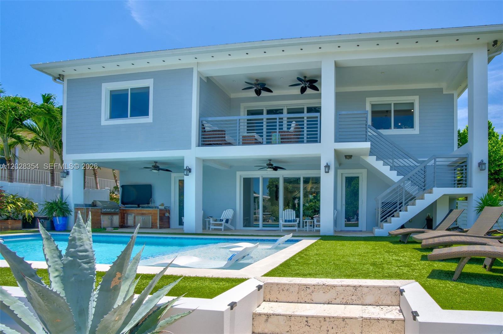 A two-story house exterior features a swimming pool, patio, outdoor kitchen, and staircase — 145 Venetian Drive, Islamorada FL 33036, ISLAMORADA, FL