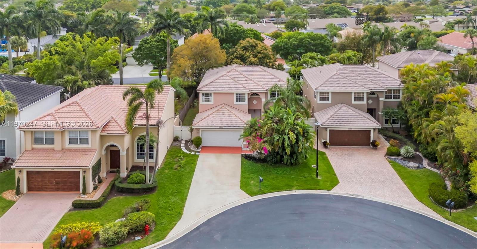 A two-story suburban house with a white garage door, tan stucco exterior, and tropical landscaping — 9480 Baritone Ct, Boca Raton FL 33496, BOCA RATON, FL