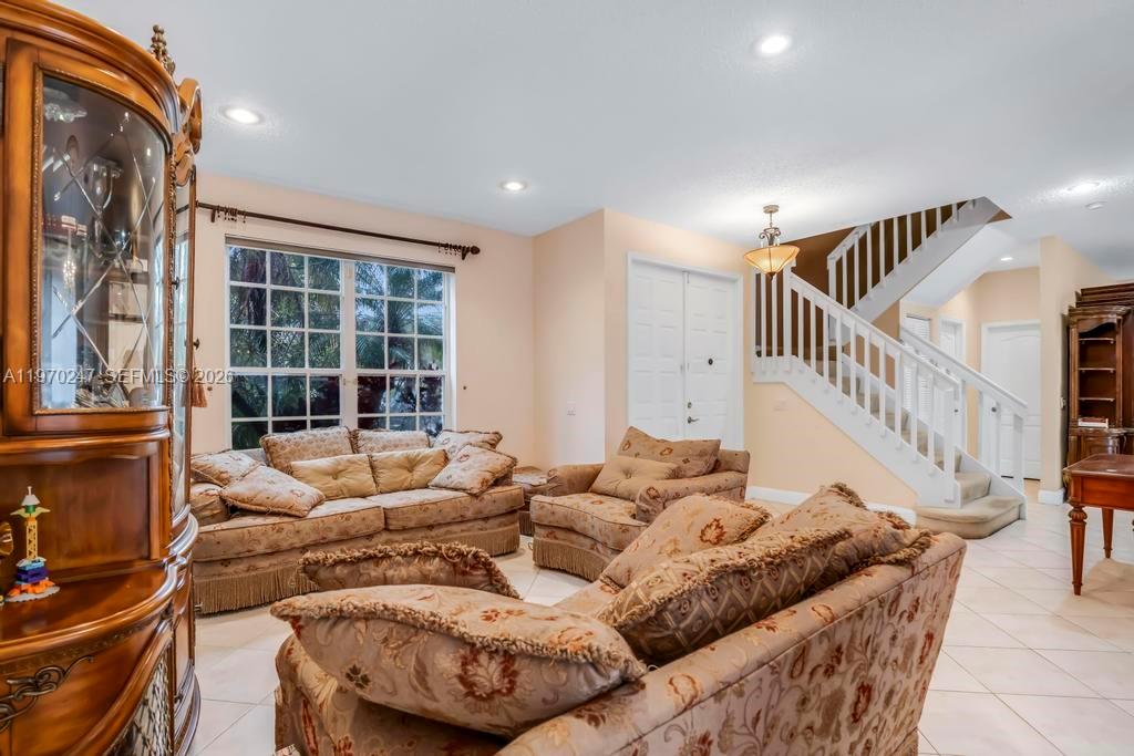 A kitchen features white cabinets, stainless steel appliances, and light-colored tile flooring — 9480 Baritone Ct, Boca Raton FL 33496, BOCA RATON, FL