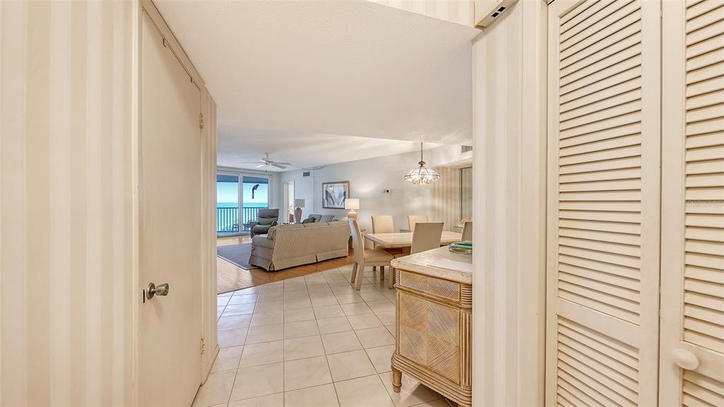 A view from a tiled hallway looking into a living and dining area with ocean views — 4825 GULF OF MEXICO DRIVE UNIT 504, LONGBOAT KEY, FL
