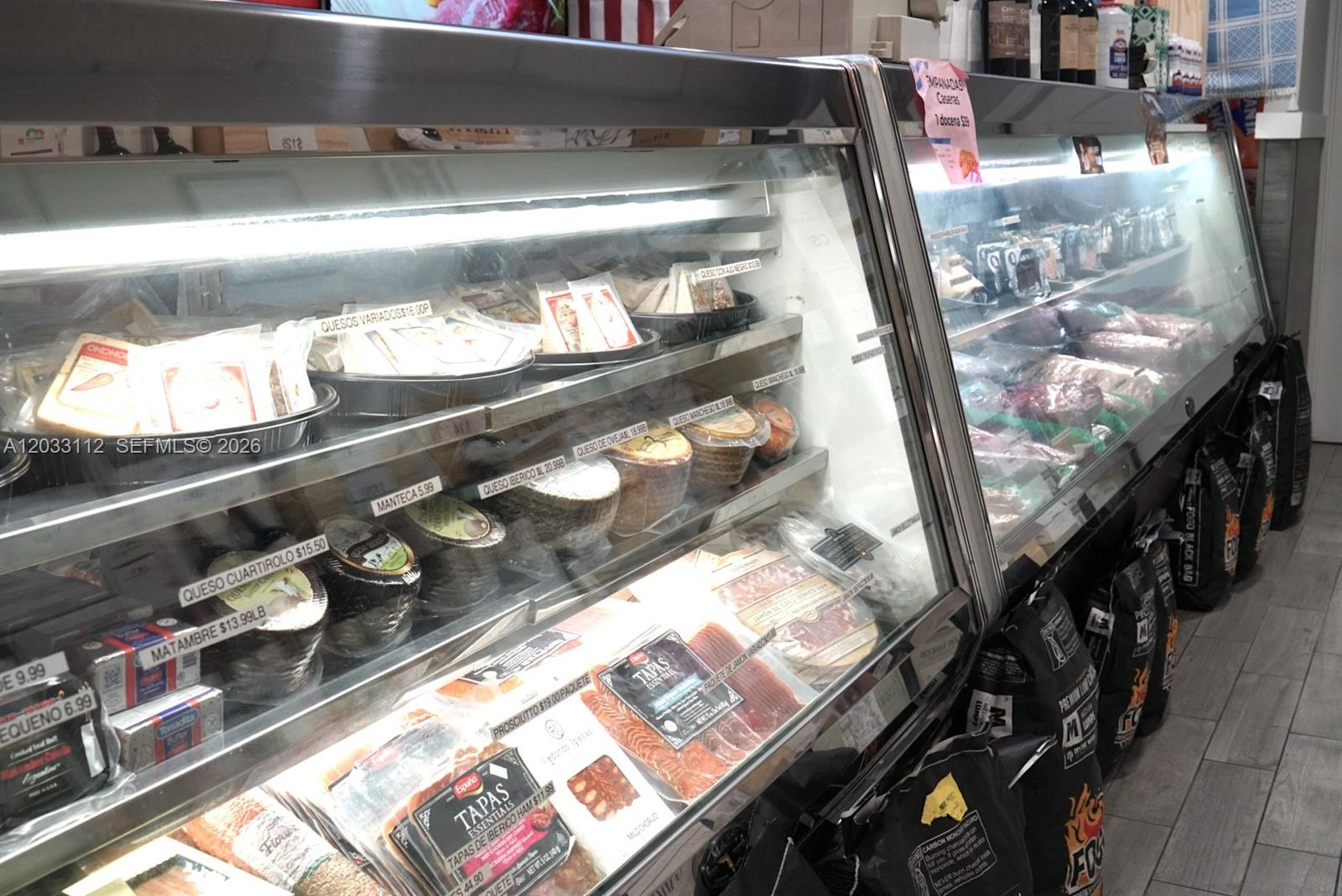 A refrigerated display case in a store contains various cheeses, meats, and packaged food items — 2752-2756 SW 137TH  AVE, Kendall FL 33175, KENDALL, FL