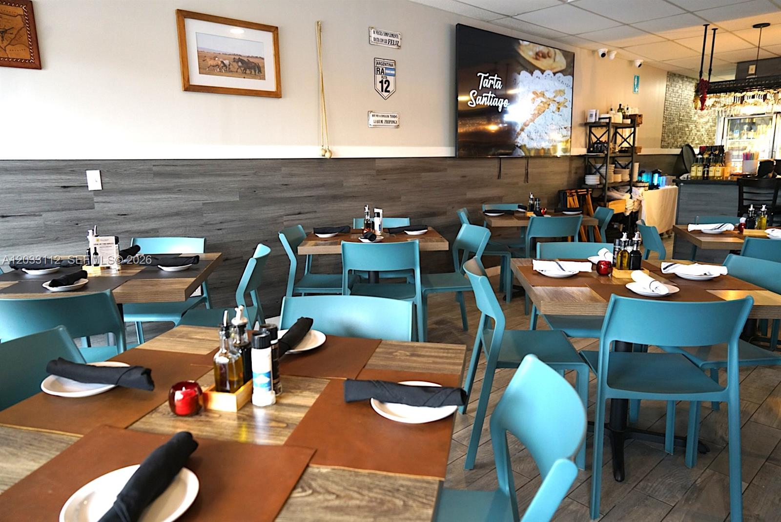 A restaurant dining room features teal chairs, wooden tables, and wood-paneled walls — 2752-2756 SW 137TH  AVE, Kendall FL 33175, KENDALL, FL