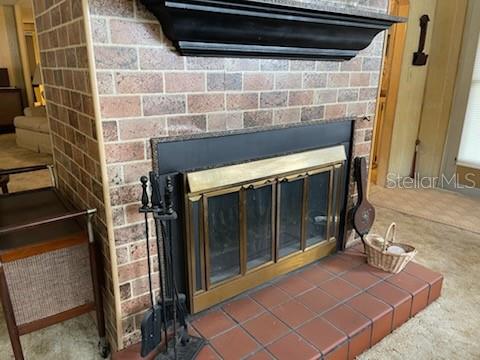 A brick fireplace features a black mantel, brass-trimmed glass doors, and a tiled hearth — 74 N BOBWHITE ROAD, WILDWOOD, FL