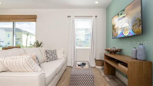 A living room features a light-colored sofa, a patterned ottoman, and a wall-mounted television — 8123 COCONUT PLACE, KISSIMMEE, FL