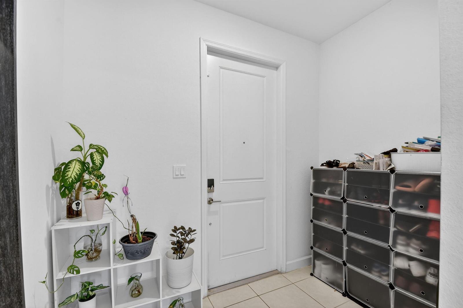 An entryway features a white door, a white plant shelf, and a modular shoe rack — 4326 Hammock Grove Drive, Lake Worth FL 33467, LAKE WORTH, FL