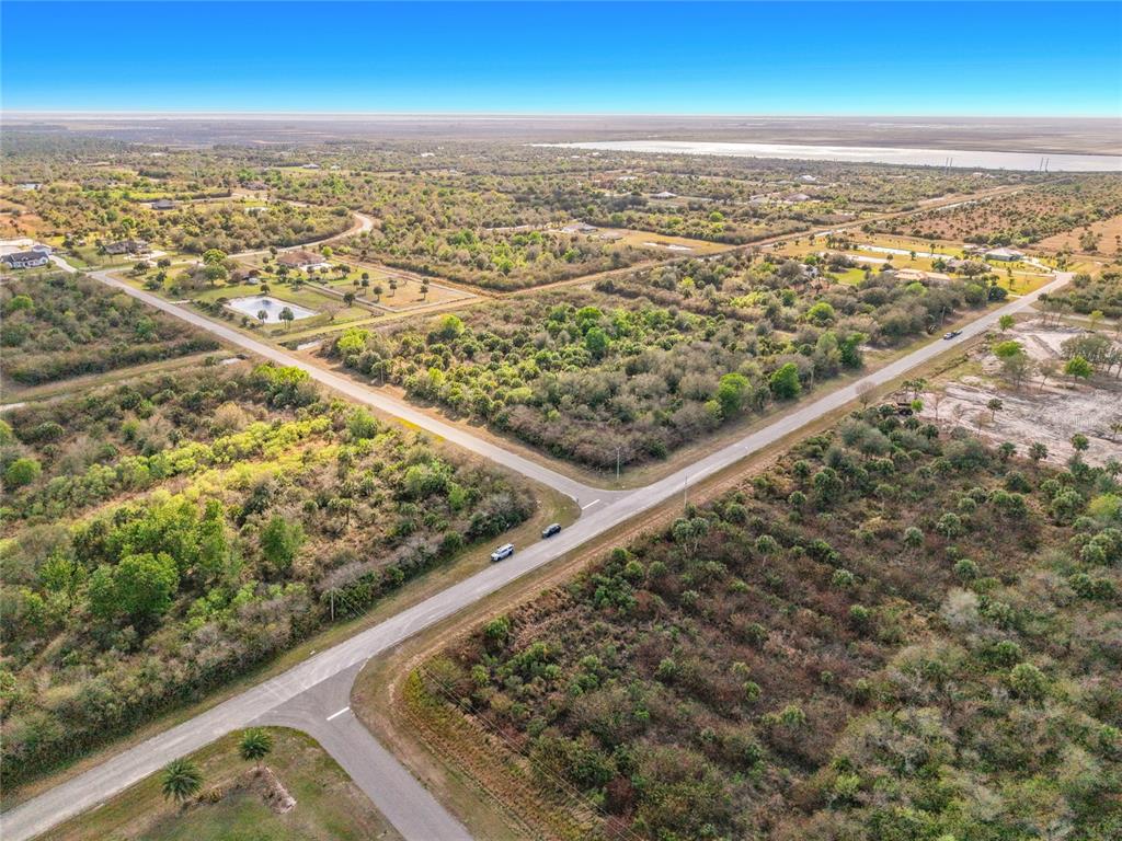 An aerial view shows a rural intersection surrounded by undeveloped land and scattered residential properties — FAWN TRAIL STREET, PALM BAY, FL