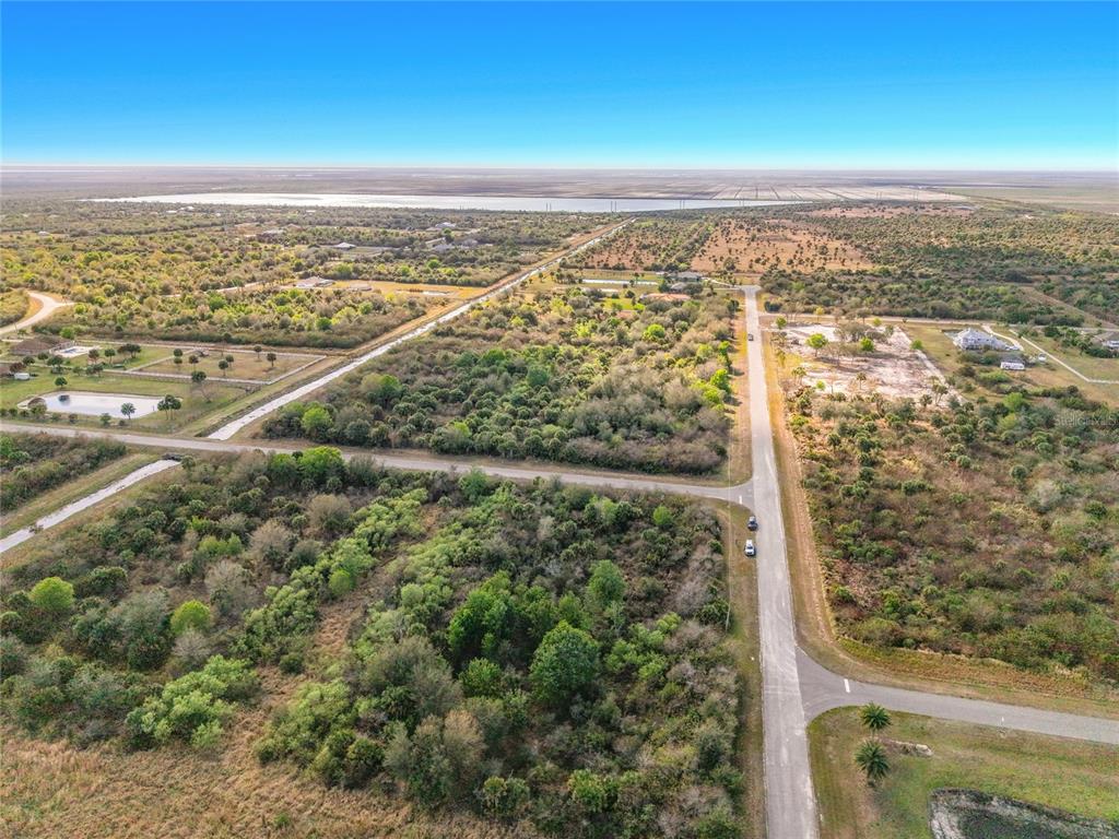 An aerial view shows a rural landscape with intersecting paved roads, scattered vegetation, and distant water — FAWN TRAIL STREET, PALM BAY, FL