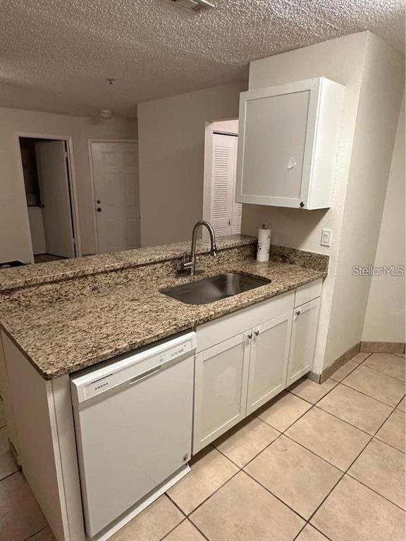 A kitchen features a granite countertop, stainless steel sink, white cabinets, and a dishwasher — 976 LEEWARD PLACE UNIT 103, ALTAMONTE SPRINGS, FL