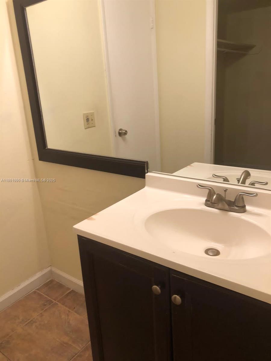 A bathroom features a white vanity with a sink, a dark-framed mirror, and tiled flooring — 492 NW 165th St Rd # C514, Miami FL 33169, MIAMI, FL
