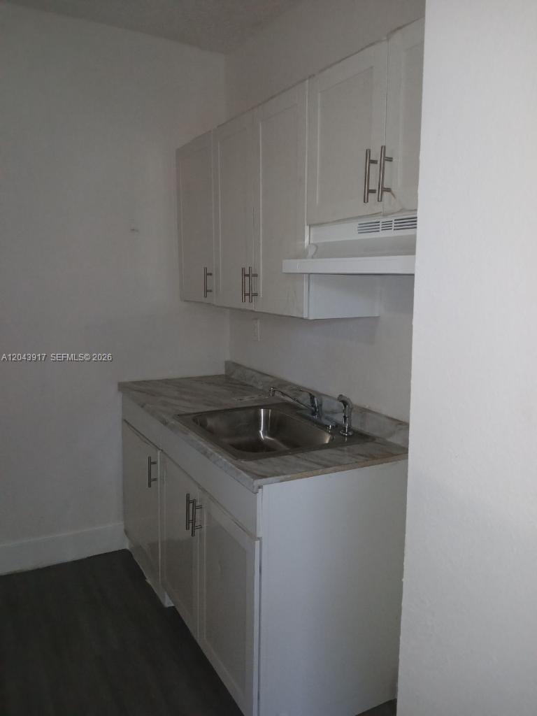 A small kitchen features white cabinets, a stainless steel sink, and a laminate countertop — 1003 SW 15th Ave # 6, Miami FL 33135, MIAMI, FL