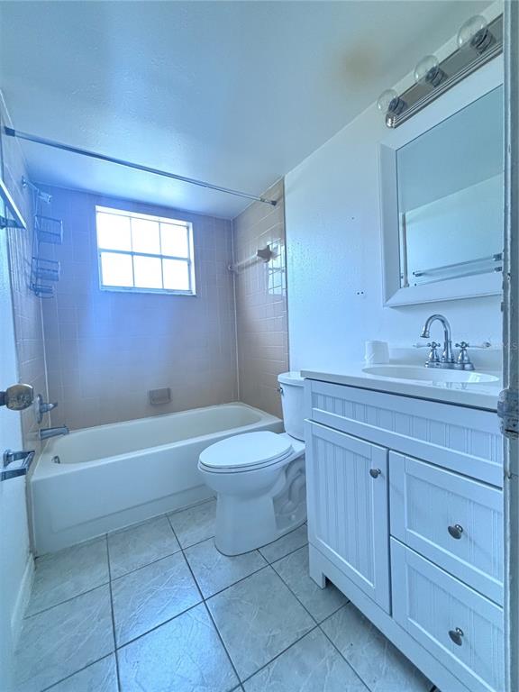 A bathroom features a white vanity, a toilet, and a bathtub with pink tile walls — 576 FAIRWAYS LANE UNIT M104, OCALA, FL