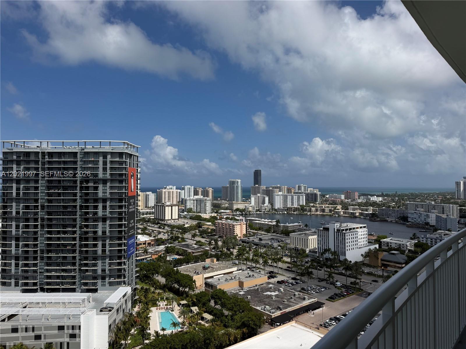 An elevated view shows a high-rise building overlooking a city skyline, a bay, and ocean — 1755 E Hallandale Beach Blvd # 2404E, Hallandale Beach FL 33009, HALLANDALE BEACH, FL