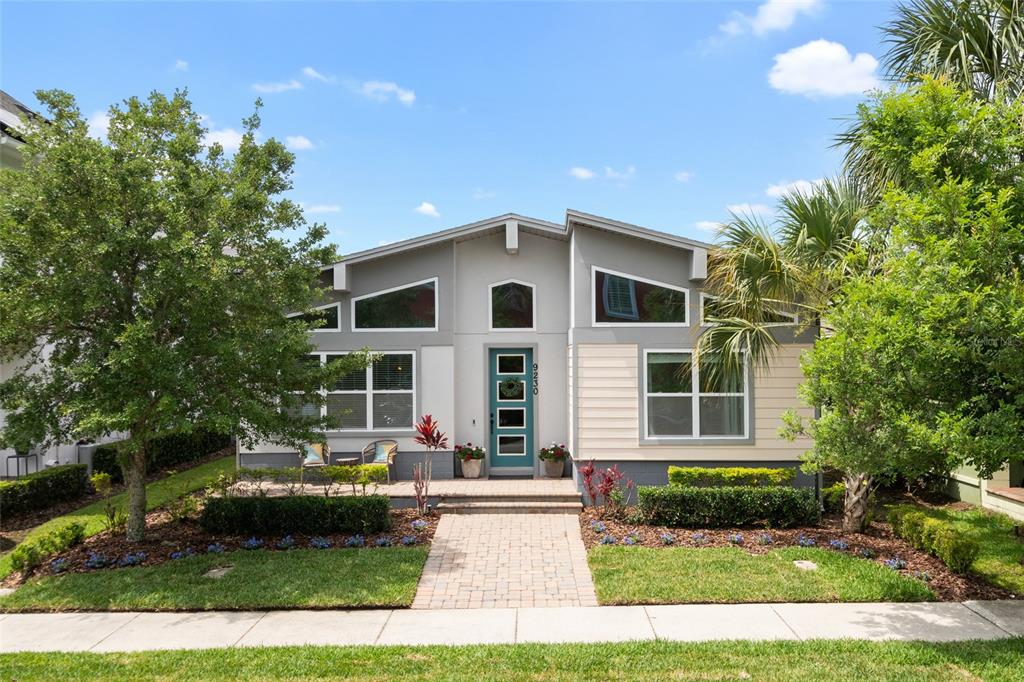 A single-story house with a teal front door, angled windows, and a paved walkway — 9230 YONATH STREET, ORLANDO, FL
