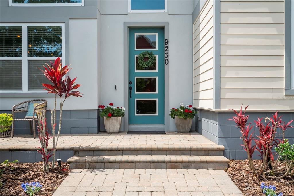 A teal front door with four glass panels sits at the top of stone steps — 9230 YONATH STREET, ORLANDO, FL