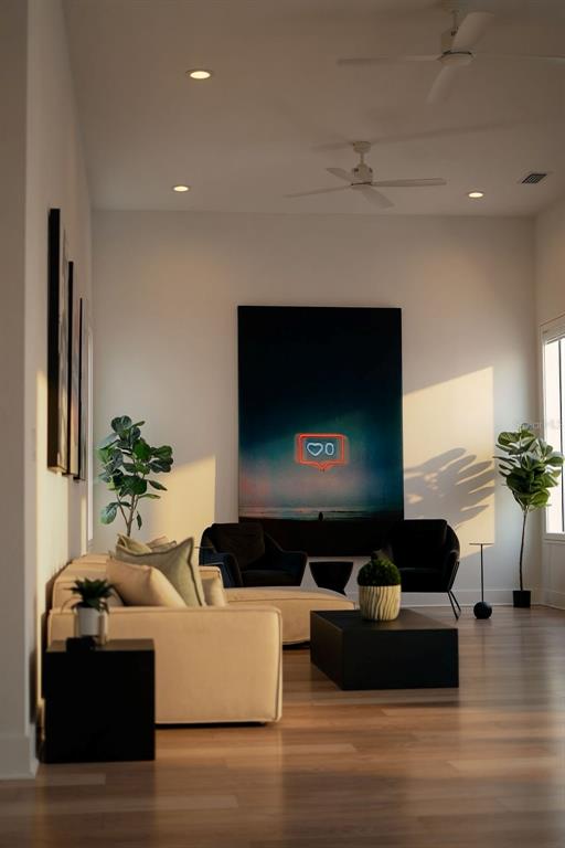 A modern living room features a large neon-style wall art piece, light flooring, and two ceiling fans — 2701 N POPLAR AVENUE, TAMPA, FL