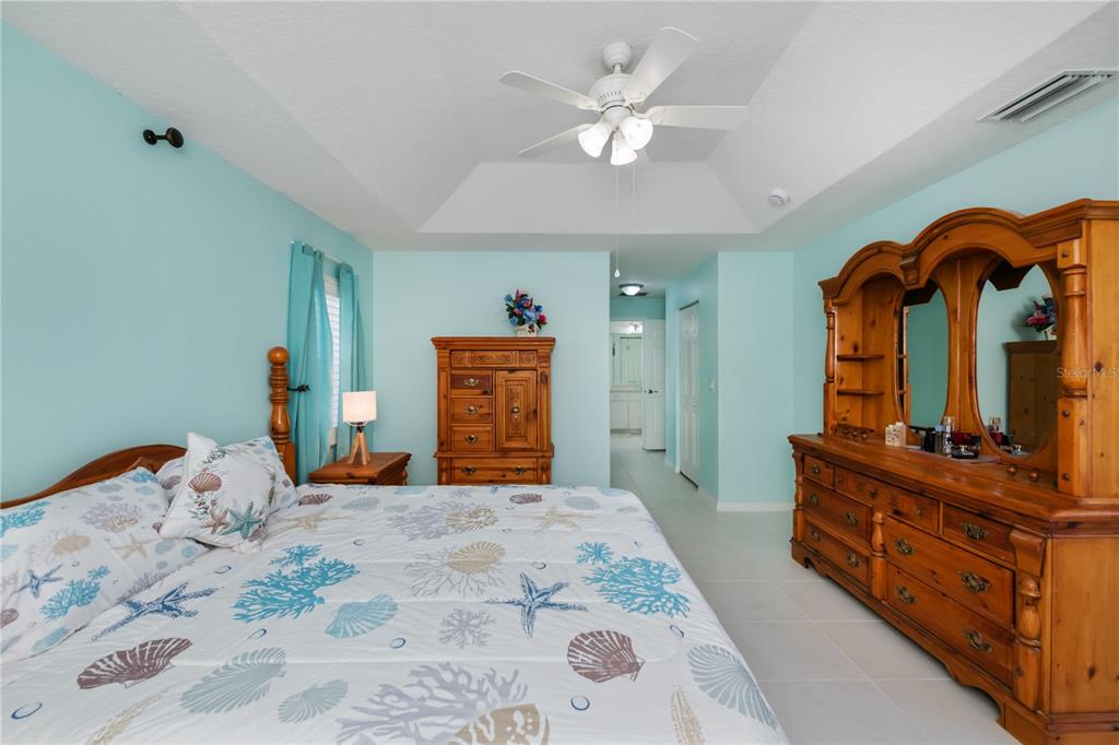 A kitchen features white cabinets, light countertops, a white stove, and a teal accent wall — 409 BOUNDARY BOULEVARD, ROTONDA WEST, FL