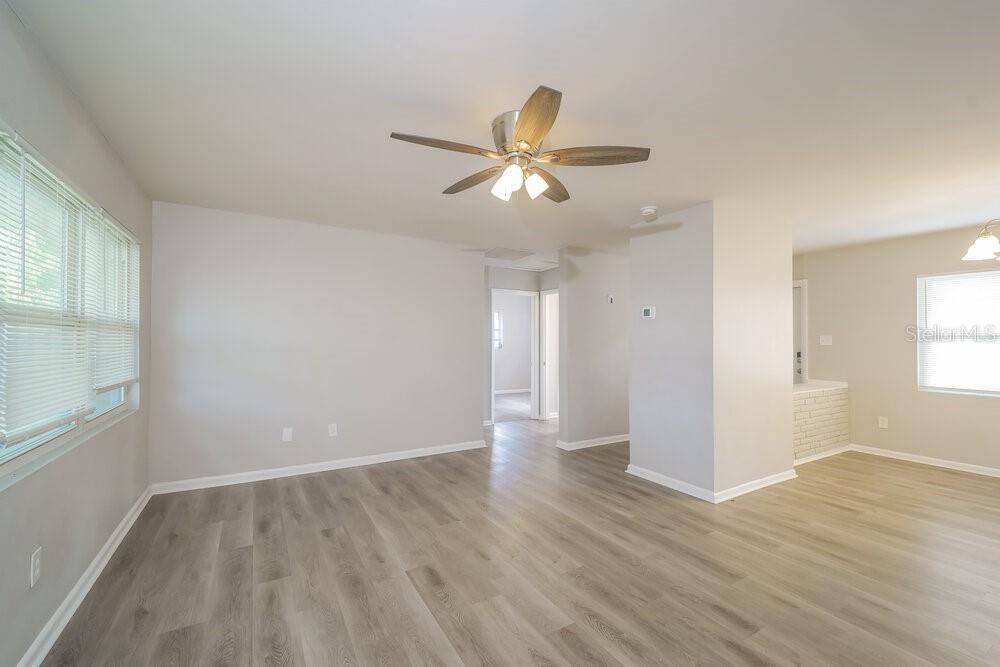 A bright living room features light gray walls, wood-look flooring, and a ceiling fan — 4346 TUFTS AVENUE, FORT MYERS, FL