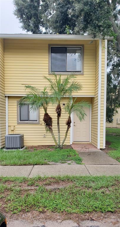 A two-story yellow building with a palm tree, a front door, and an air conditioning unit — 22726 GAGE LOOP UNIT 41, LAND O LAKES, FL