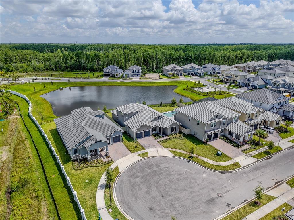 An aerial view shows a suburban neighborhood with houses, a pond, and a cul-de-sac — 14422 CREST PALM AVENUE, WINDERMERE, FL