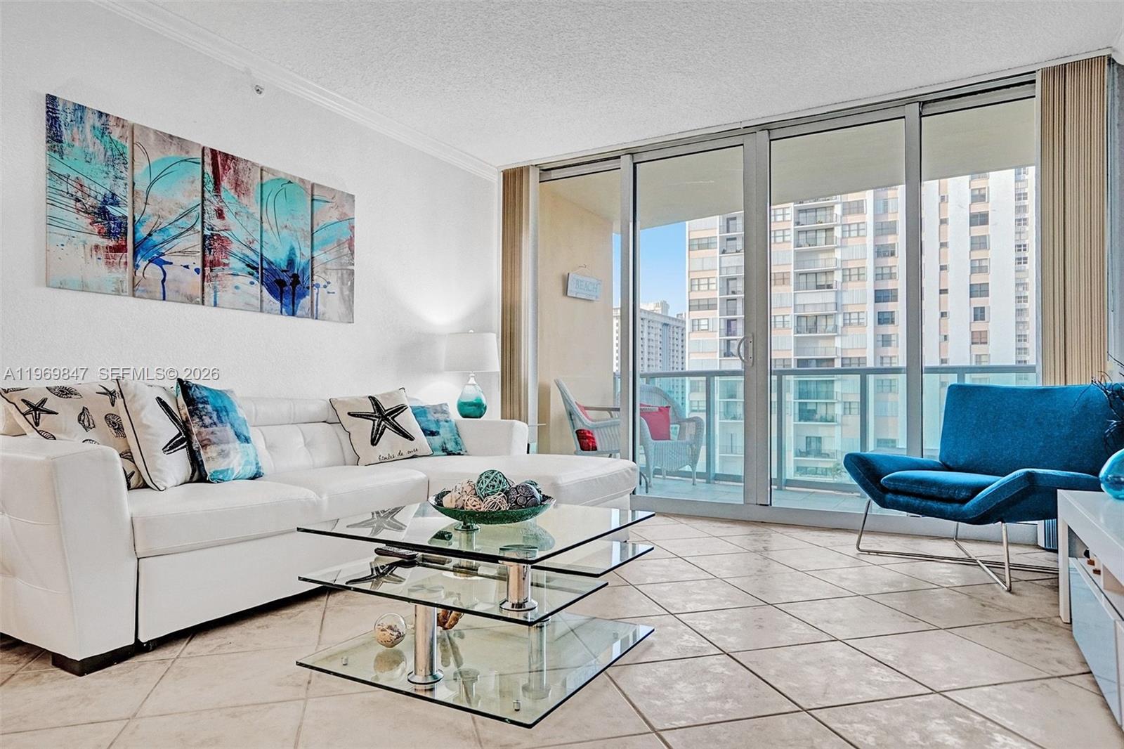 A living room features a white sectional sofa, glass coffee table, and blue accent chair — 2501 S Ocean Dr, Hollywood FL 33019, HOLLYWOOD, FL