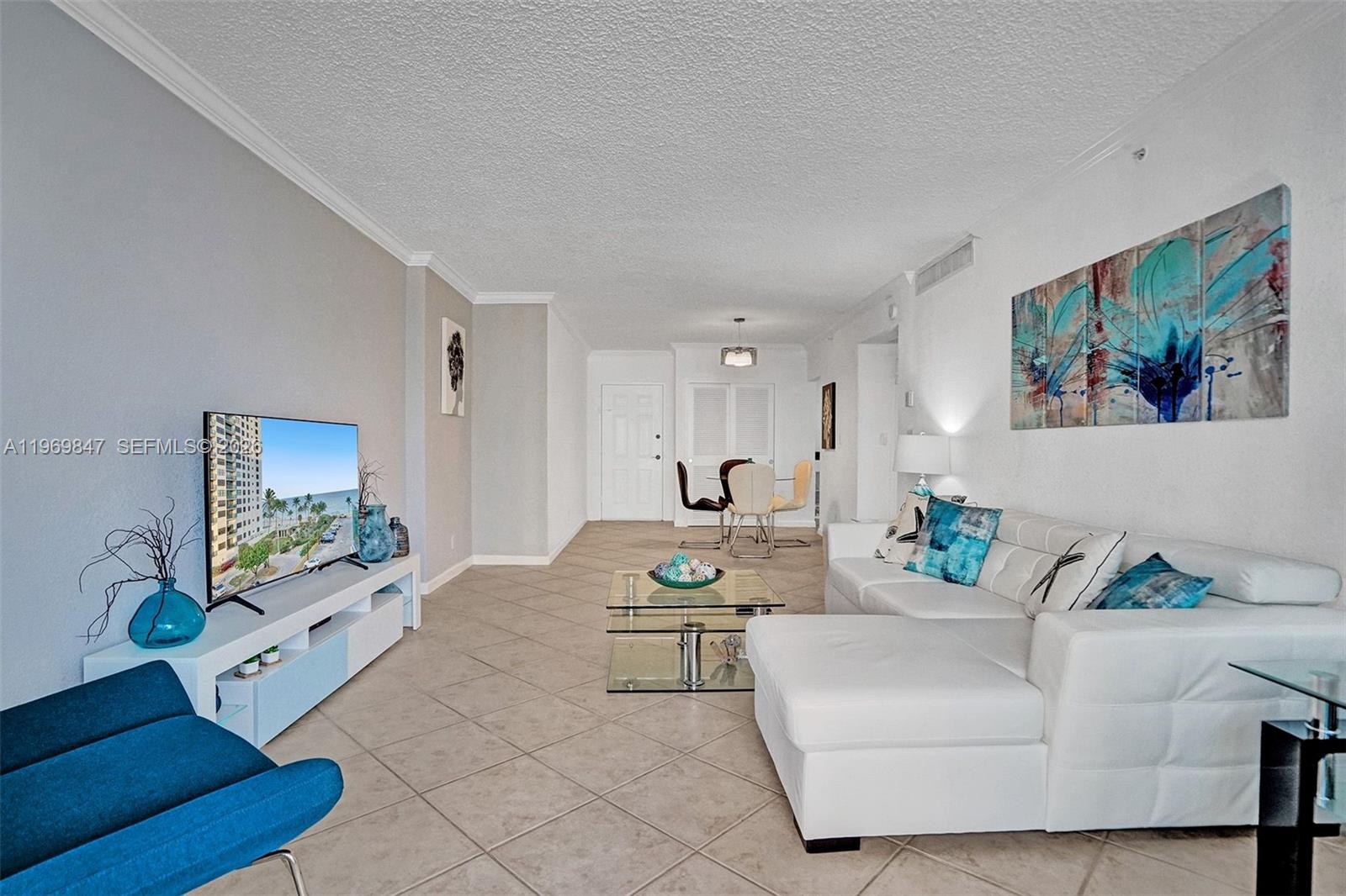 A living room features a white sectional sofa, a glass coffee table, and tile flooring — 2501 S Ocean Dr, Hollywood FL 33019, HOLLYWOOD, FL