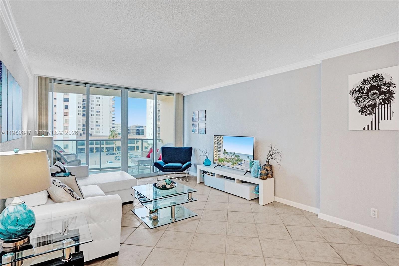 A living room features a white sectional sofa, glass coffee table, and a balcony view — 2501 S Ocean Dr, Hollywood FL 33019, HOLLYWOOD, FL