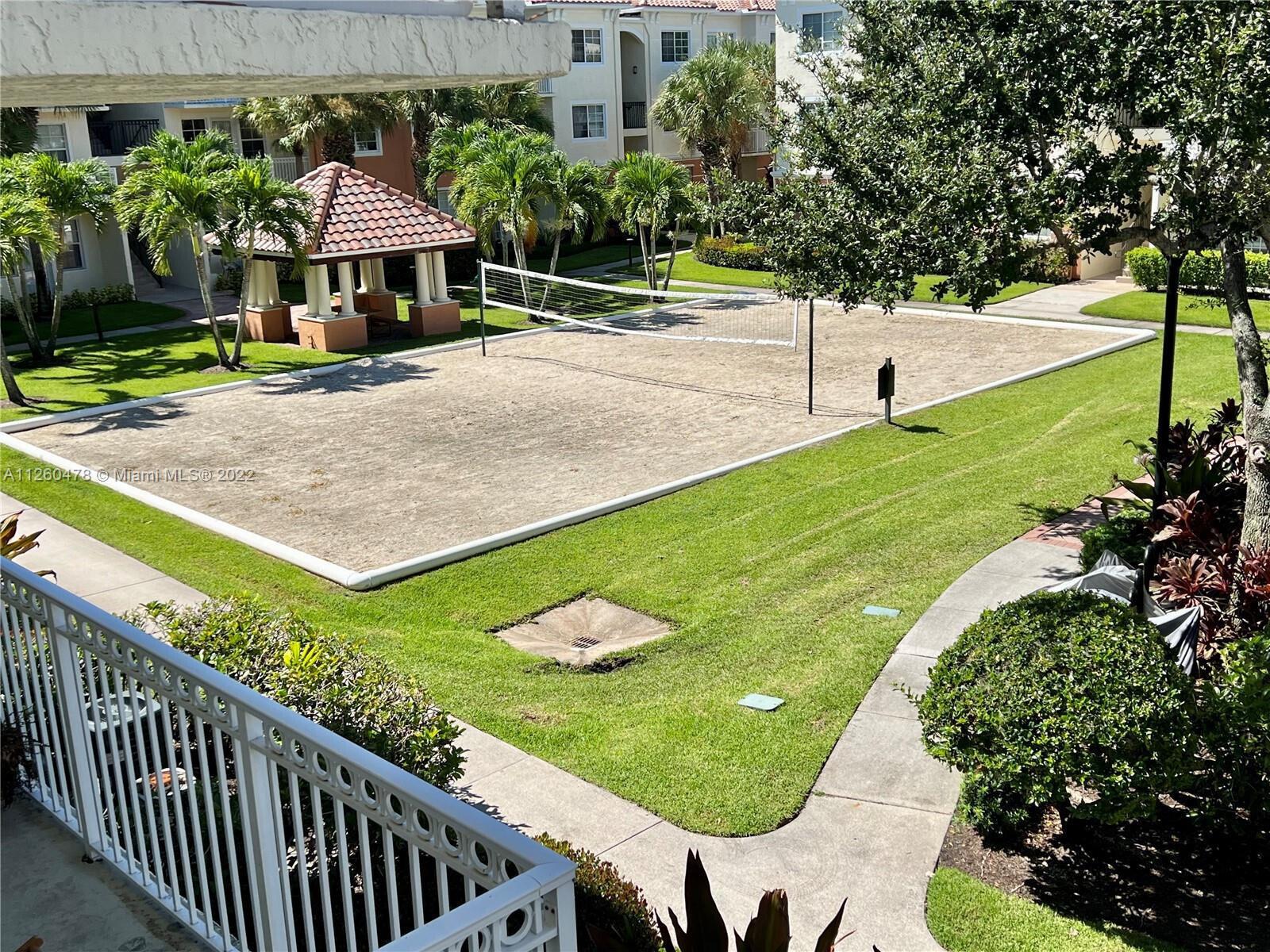 An elevated view of a sand volleyball court surrounded by grass and apartment buildings — 9887 Baywinds Drive # 4305, West Palm Beach FL 33411, WEST PALM BEACH, FL