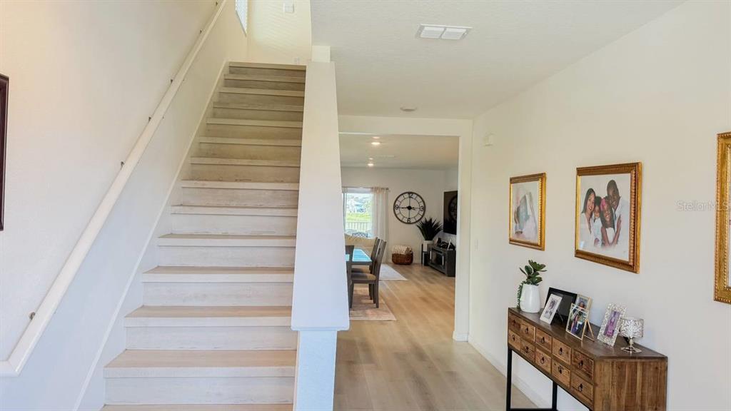 A staircase with light wood steps leads to an upper floor near a dining area — 1724 POST OAK DRIVE, DAVENPORT, FL
