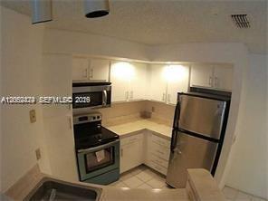 A kitchen features white cabinets, stainless steel appliances, and light-colored countertops — 3380 N Pinewalk Dr N # 1116, Margate FL 33063, MARGATE, FL