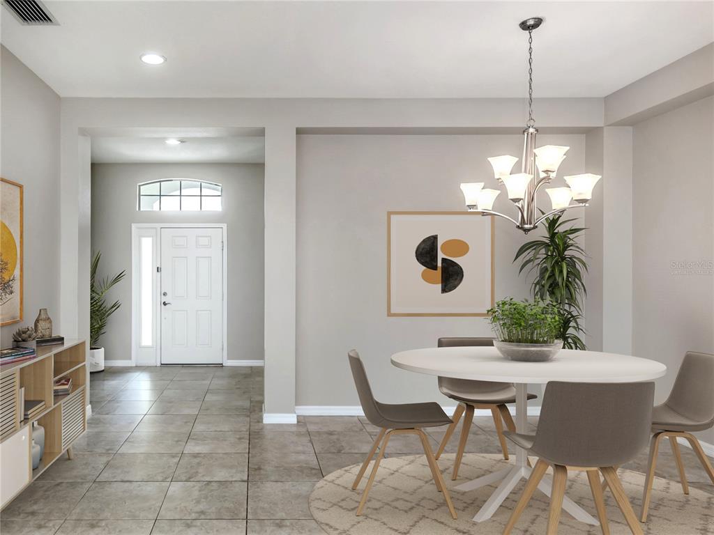 A dining area with a round table, modern chairs, and a chandelier near an entryway — 11406 BELVEDERE TERRACE, BRADENTON, FL