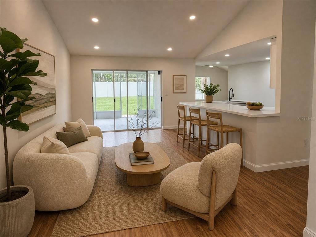 A living room with a cream sofa, accent chair, coffee table, and kitchen breakfast bar — 9207 MILL CIRCLE, TAMPA, FL