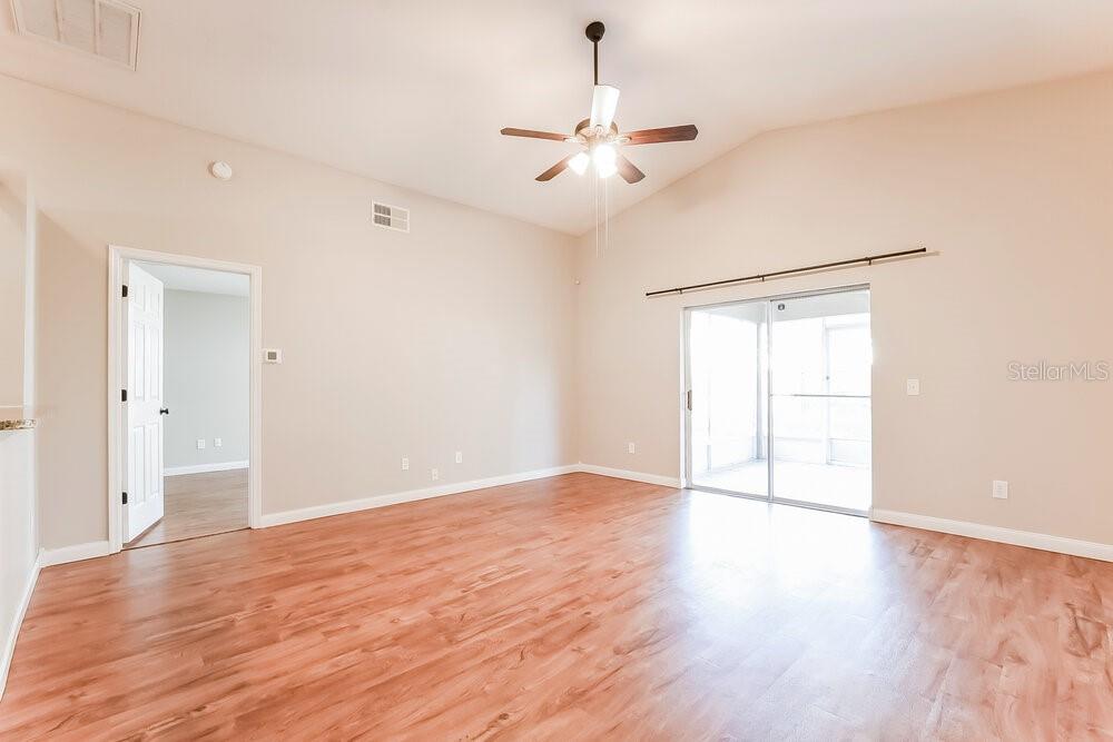An empty room with wood-look flooring, a ceiling fan, and sliding glass doors — 4166 SHADOW CREEK CIRCLE, OVIEDO, FL