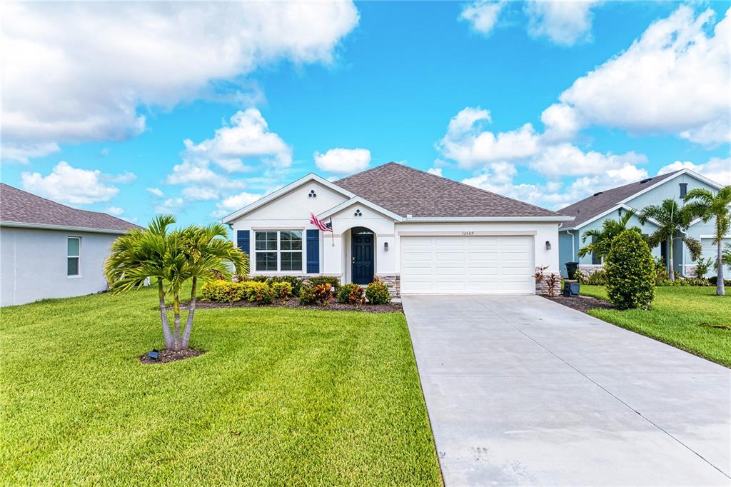 A single-story house with a white exterior, a two-car garage, and a palm tree — 12509 NIGHT VIEW DRIVE, SARASOTA, FL