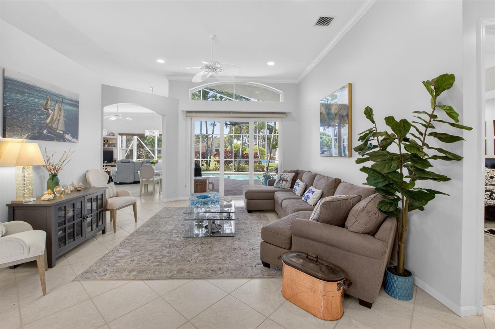 A living room features a sectional sofa, a glass coffee table, and sliding glass doors — 5312 Brooklawn Terrace, Boynton Beach FL 33437, BOYNTON BEACH, FL