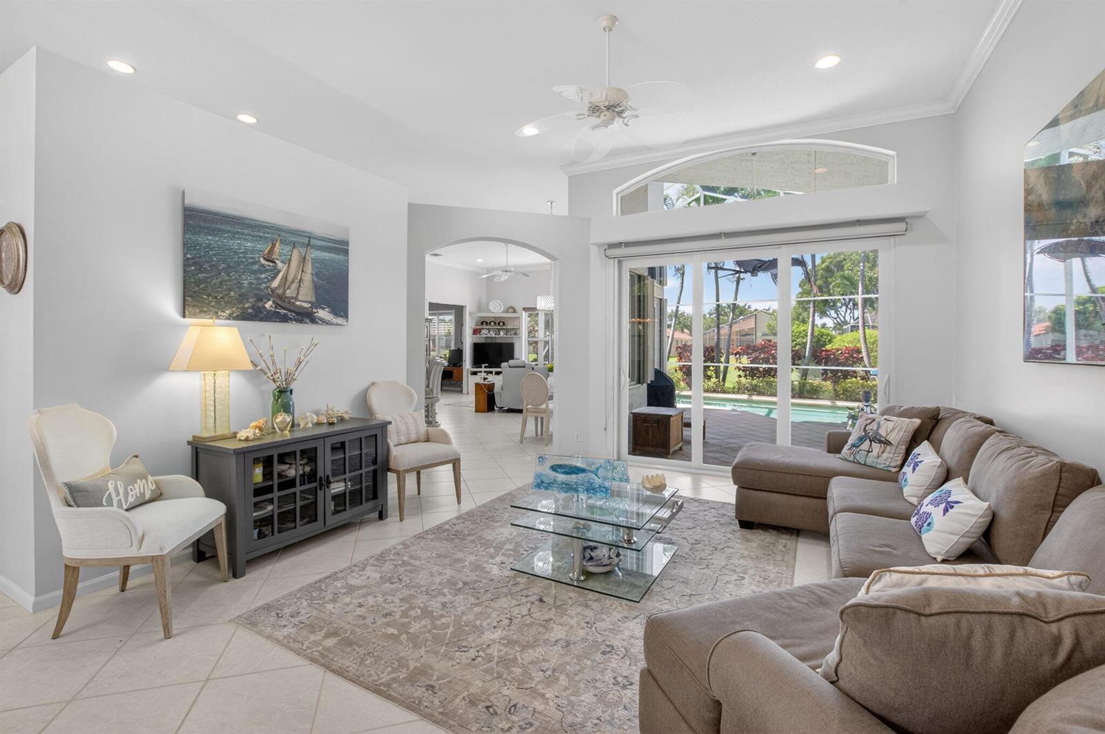 A living room with a sectional sofa, glass coffee table, and sliding doors to a pool — 5312 Brooklawn Terrace, Boynton Beach FL 33437, BOYNTON BEACH, FL
