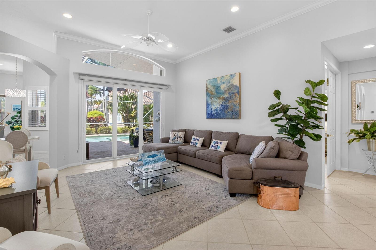 A living room features a brown sectional sofa, a glass coffee table, and sliding glass doors — 5312 Brooklawn Terrace, Boynton Beach FL 33437, BOYNTON BEACH, FL