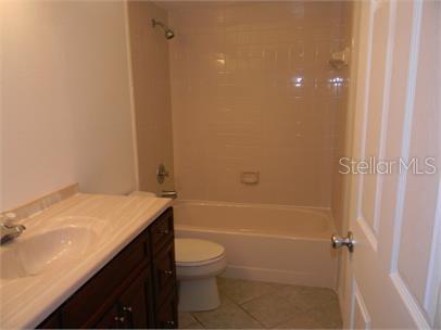 A bathroom features a dark wood vanity, a white toilet, and a shower-tub combination — 2772 GRAY FOX LANE, ORLANDO, FL