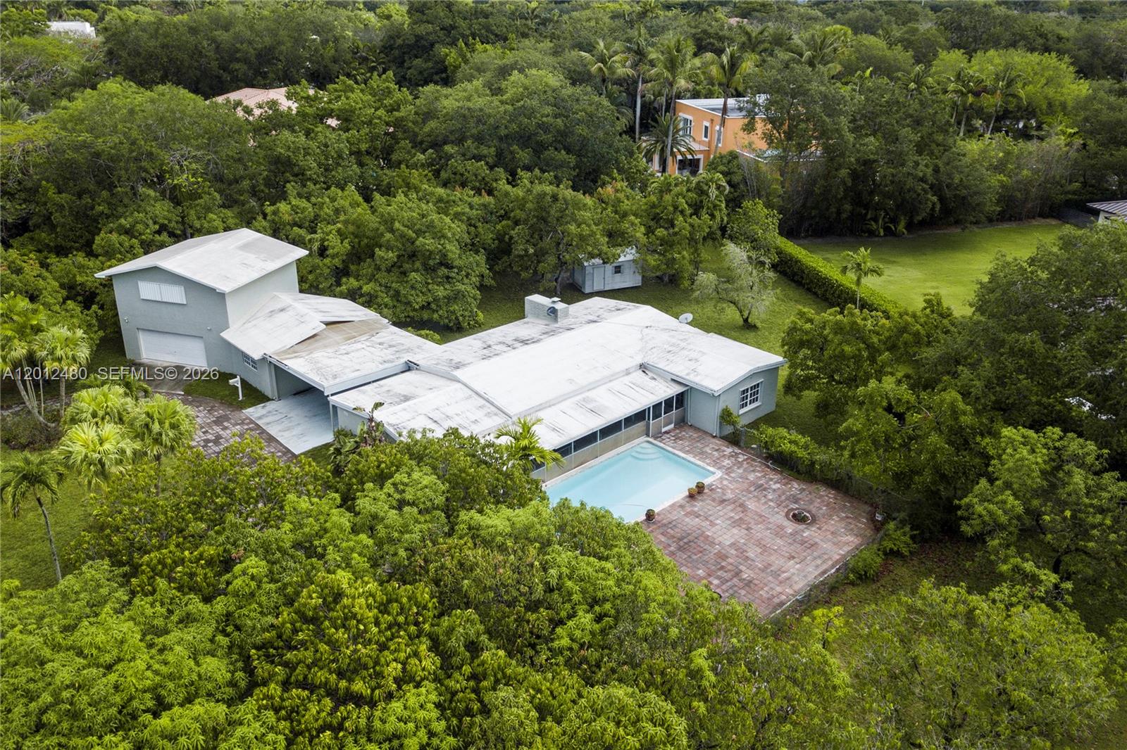 An aerial view shows a house with a swimming pool, patio, and surrounding trees — 10851 SW 68th Ave, Pinecrest FL 33156, PINECREST, FL