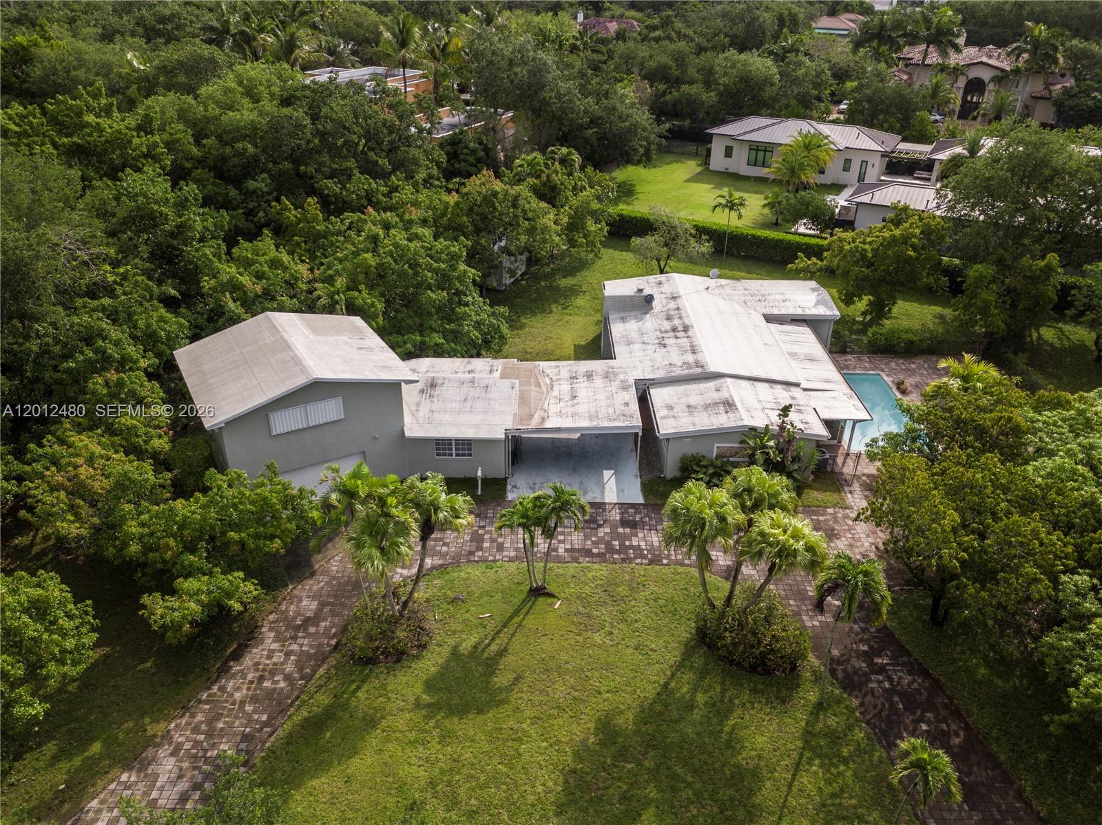 An aerial view shows a house with a flat roof, pool, and paved driveway — 10851 SW 68th Ave, Pinecrest FL 33156, PINECREST, FL