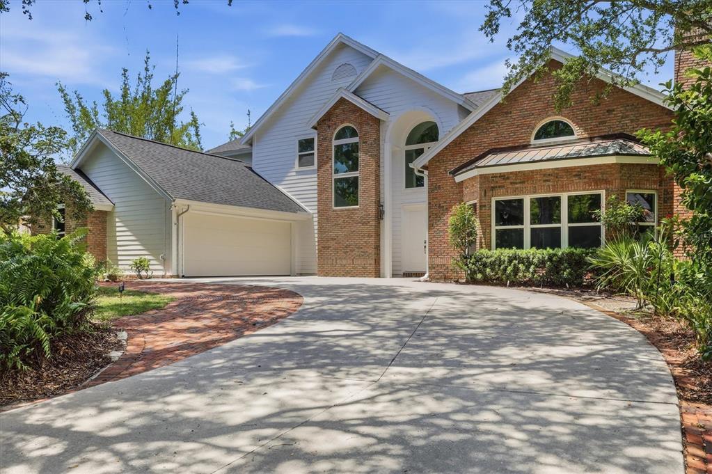 A two-story house with a brick and white siding exterior, garage, and concrete driveway — 1351 DIXIE LEE LANE, SARASOTA, FL