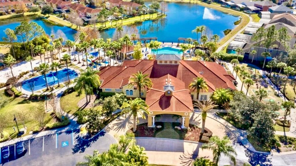 An aerial view shows a community clubhouse with a red-tiled roof, pools, and surrounding landscaping — 151 HIDEAWAY BEACH LANE, KISSIMMEE, FL