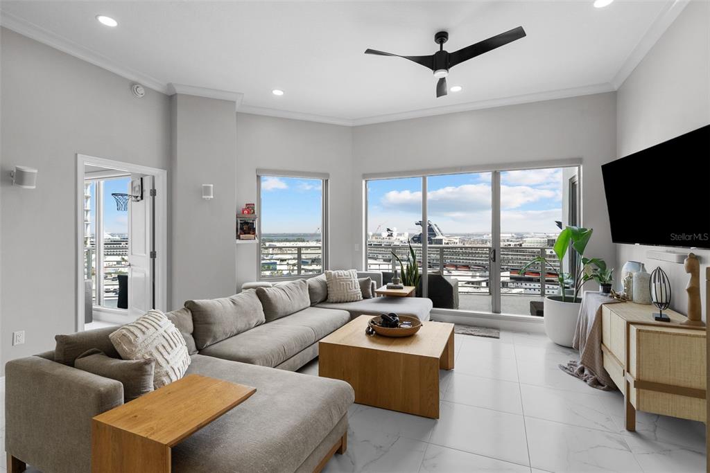 A modern living room features a gray sectional sofa, light wood coffee table, and balcony views — 449 S 12TH STREET UNIT 1402, TAMPA, FL