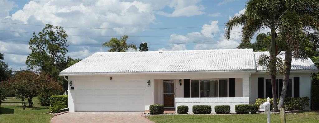 A white, single-story house with a tiled roof, a two-car garage, and a palm tree — 4031 93RD TERRACE N UNIT 5, PINELLAS PARK, FL