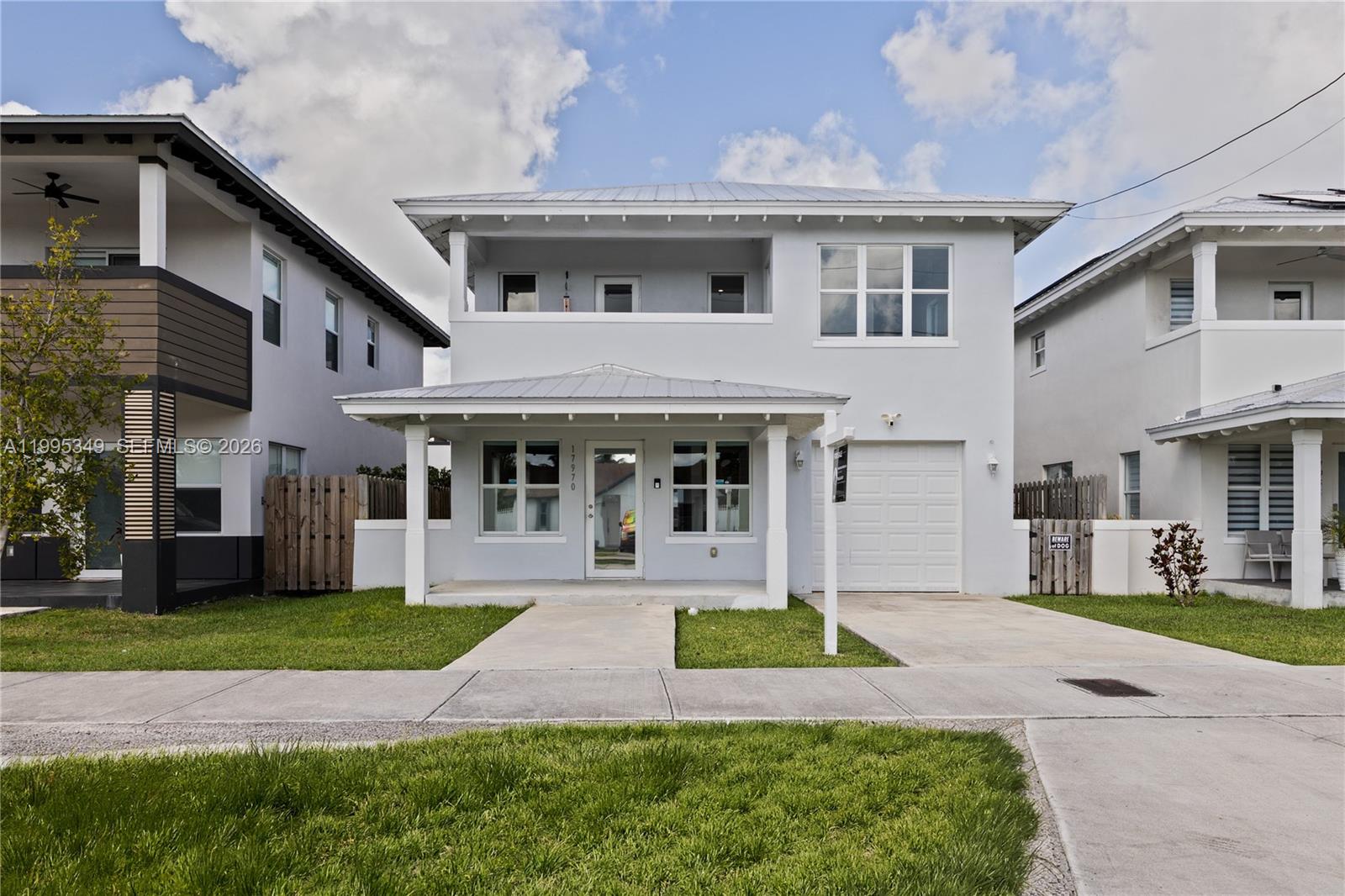 A two-story light gray house with a front porch, metal roof, and attached garage — 17970 SW 105th Ave, Miami FL 33157, MIAMI, FL